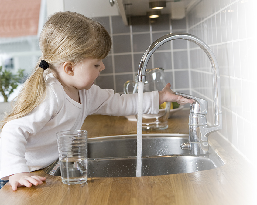 A girl turning on the water faucet.